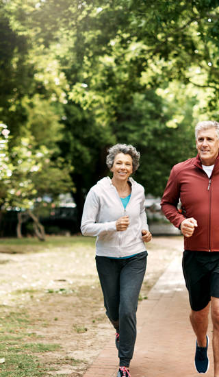 Full length shot of a senior couple taking a run through the park
